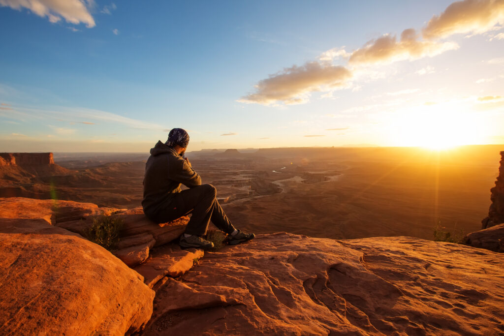 Contemplating sunrise over canyons